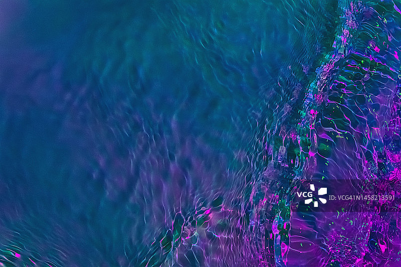 空灵的深色全息紫色、粉色、绿色透明水面波纹纹理图片素材