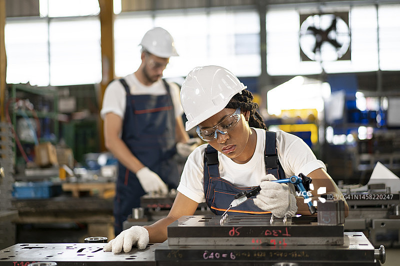 机械工程师在工业建筑中工作，装配后检查机器图片素材