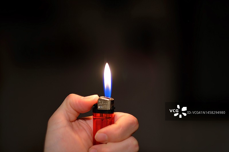 打火机火焰和点燃的手图片素材