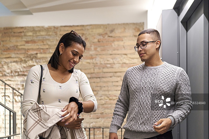 多元种族夫妇在公寓外搬家，女子正在做手势图片素材