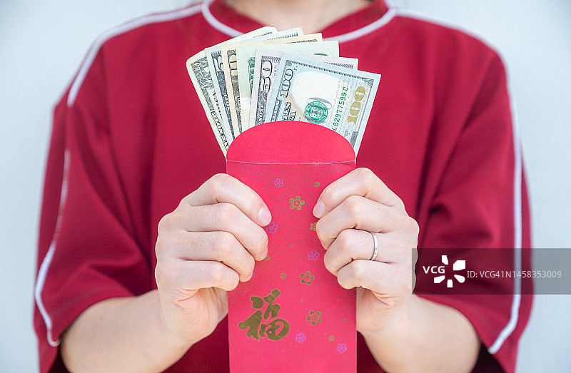 特写：女性手持装有美元的红包图片素材
