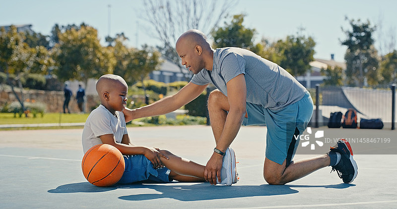 受伤，腿痛和父亲与儿子在篮球场上进行体育运动、训练和锻炼。医疗、健康和黑人家庭，孩子和爸爸接受伤口、疼痛和治疗的急救图片素材