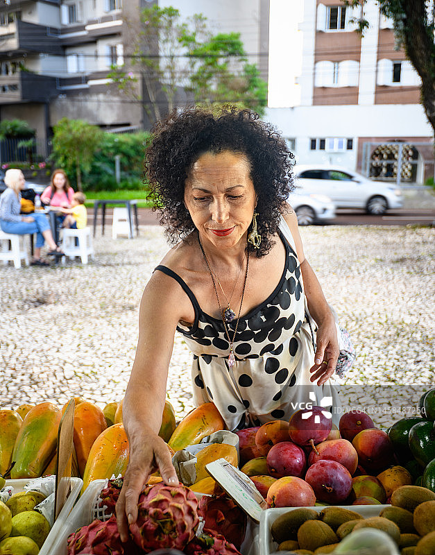 在市场摊位寻找水果的女人图片素材