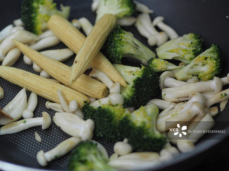 玉米笋、蟹味菇、西兰花平底锅炒制图片素材
