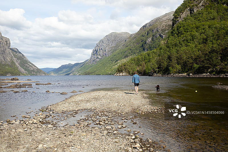 一名男子在湖边遛狗图片素材
