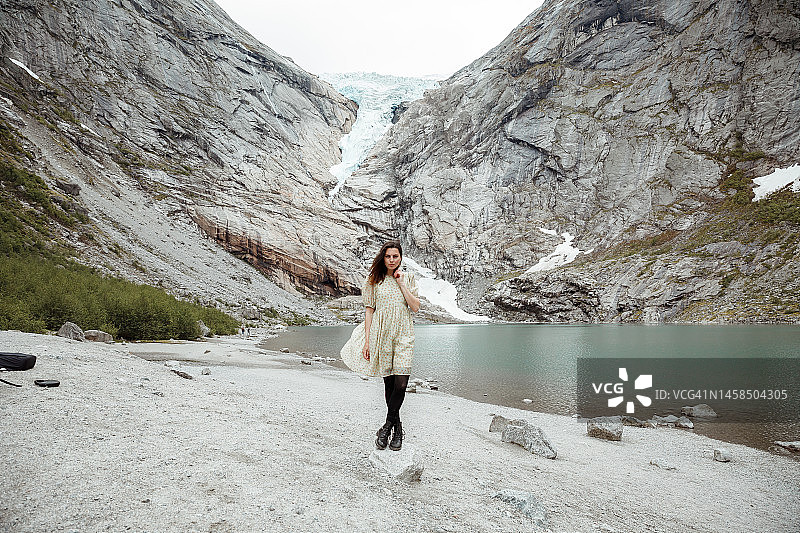 站在挪威布里克斯达尔冰川前的女子图片素材