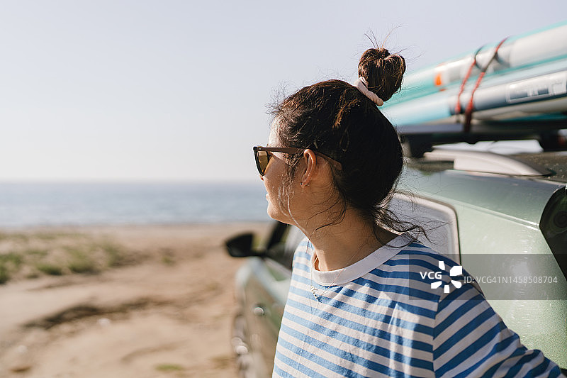 将冲浪板绑在车顶上的女性冲浪者图片素材