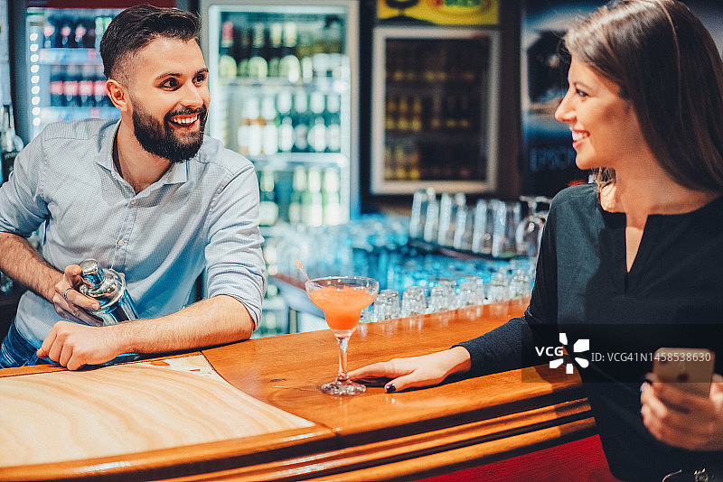 调酒师在酒吧和一位年轻女人调情图片素材