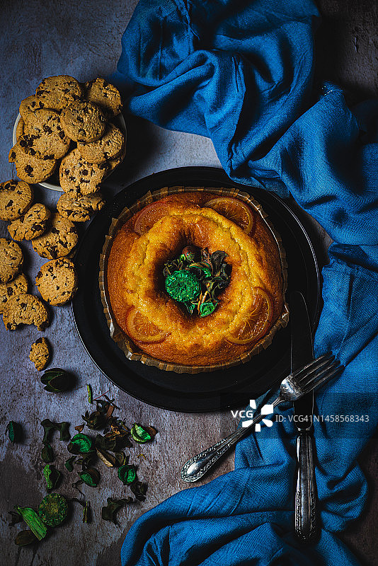 橙子蛋糕、巧克力饼干和复古餐具的俯视照片图片素材