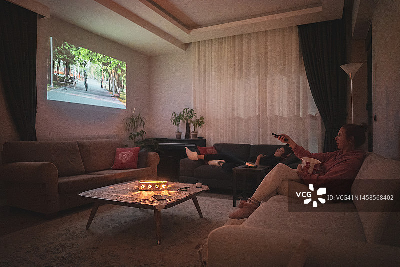 女人在家中客厅观看投影电影图片素材