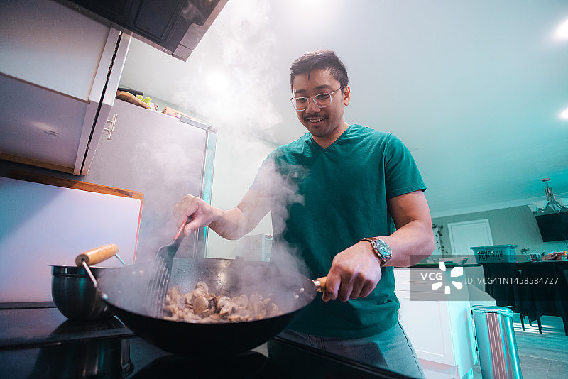 在家烹饪——炒蘑菇——用炒锅烹饪——低角度图片素材