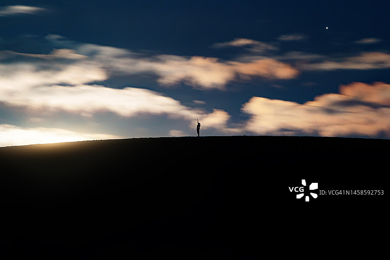 山丘上连衣裙女孩剪影，触碰天空，月升前的女孩剪影，壮丽的背景图片素材