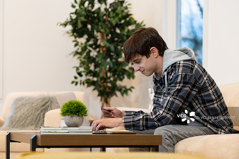 年轻拉丁裔男子在家使用电脑图片素材