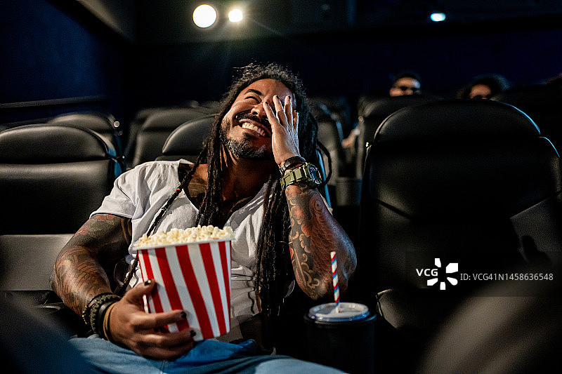 留着脏辫的男子在电影院看电影图片素材