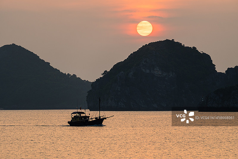 越南下龙湾吉婆岛日落时分的船只图片素材