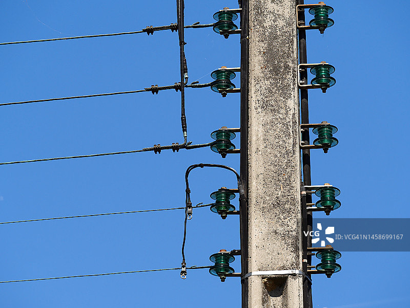 法国蓝天下带有电缆和绝缘子的电线杆特写图片素材