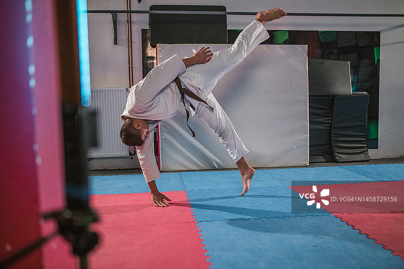 一位年轻运动员练习合气道中的摔倒技巧图片素材