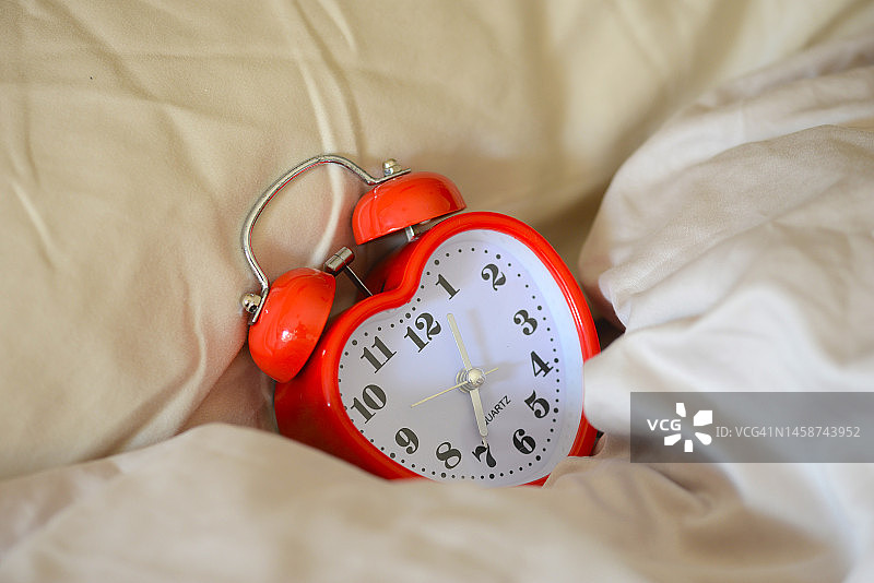枕头下的心形闹钟图片素材