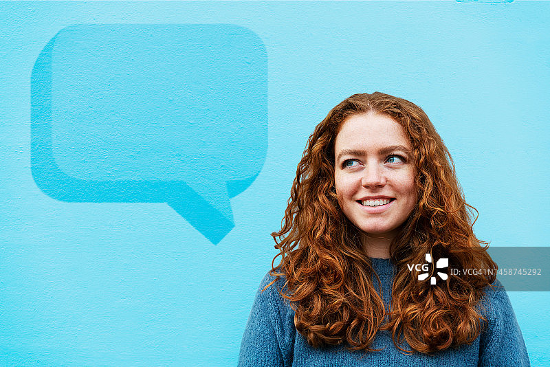 在彩色墙前看对话气泡的女人图片素材