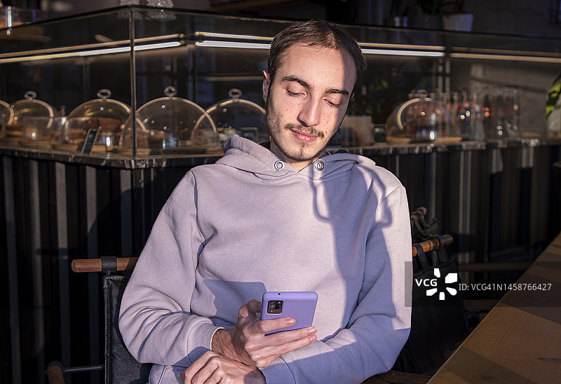 在咖啡馆看手机的年轻人图片素材