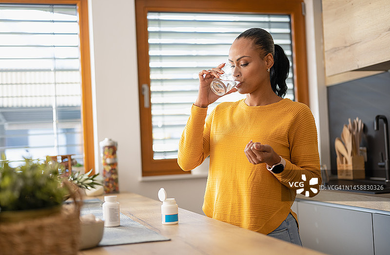 年轻女子在家服药图片素材