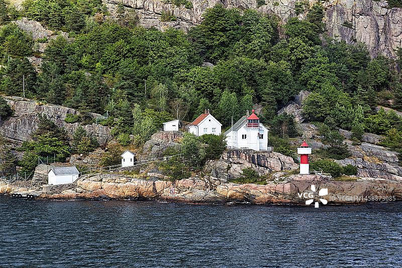 挪威阿格德尔郡克里斯蒂安桑奥德罗亚半岛悬崖上的红白灯塔图片素材