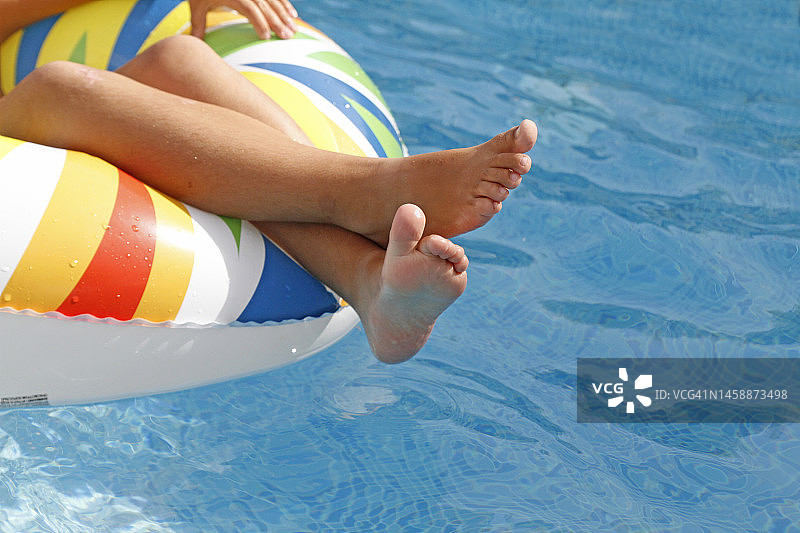 儿童躺在游泳池充气圈里的特写图片素材