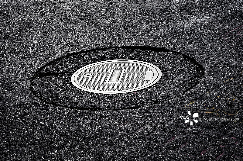 城市街道上闪亮的人孔盖图片素材