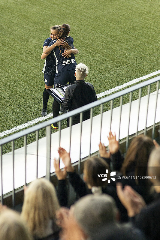 在体育场比赛中互相拥抱的女足球运动员图片素材