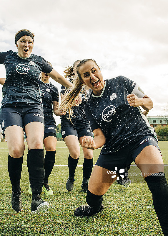 女足球员在体育场比赛中欢呼雀跃庆祝进球图片素材