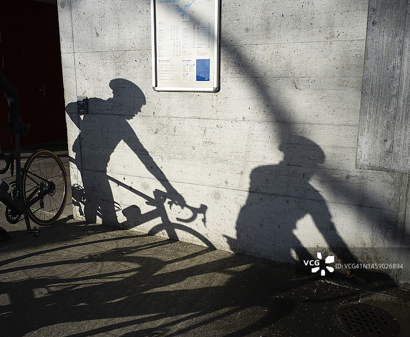 比尔：墙上的人物与自行车倒影图片素材
