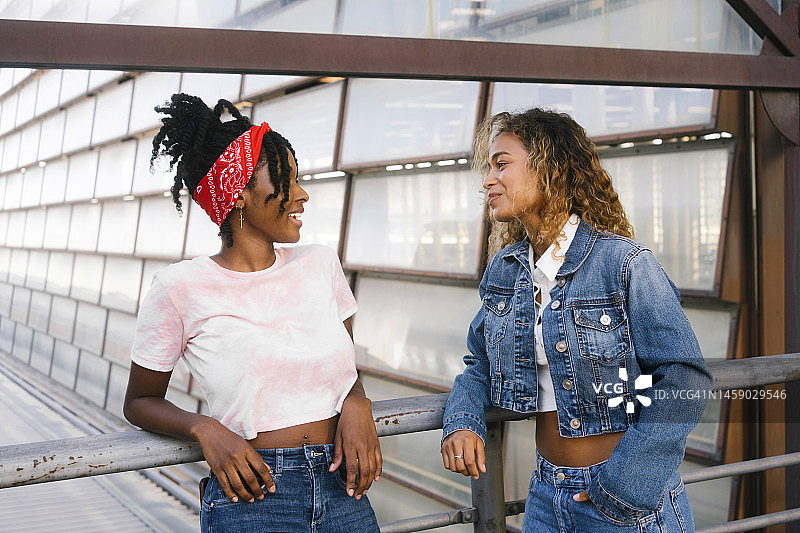 多民族年轻女性在栏杆附近交谈图片素材
