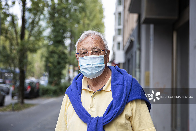 人行道上戴防护口罩的老年男人图片素材