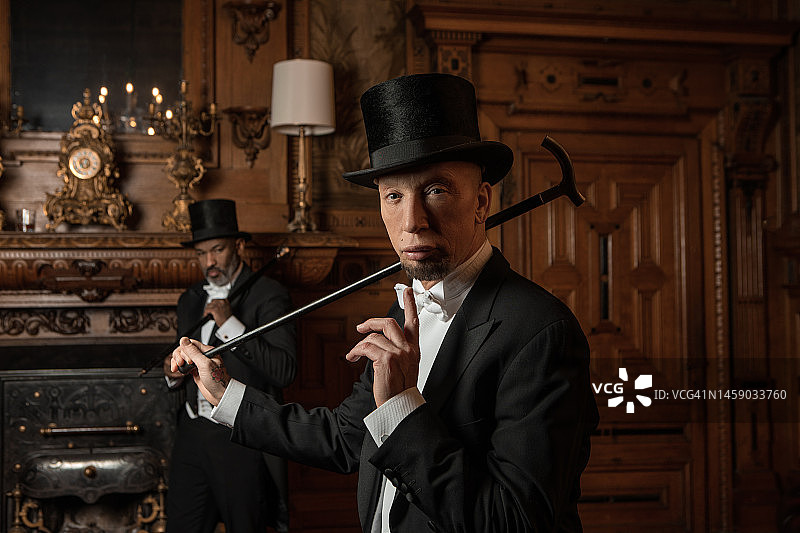 在豪华棕色酒吧里的两位英俊的20世纪20年代风格男士图片素材