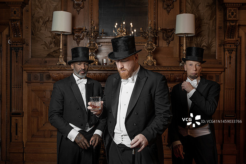 三位1920年代风格的英俊男士在豪华庄园图片素材