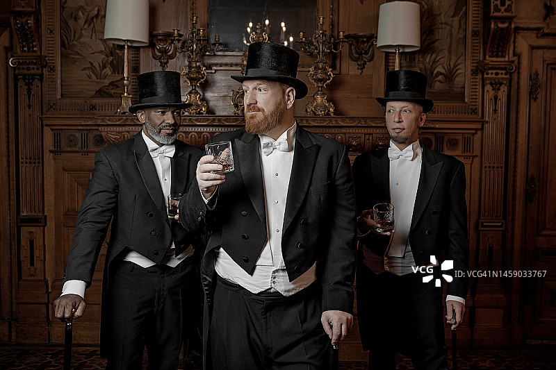 三位1920年代风格的英俊男士在豪华庄园图片素材