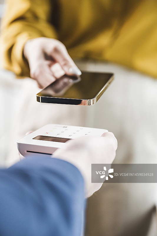 女商人通过智能手机在信用卡读卡器上支付图片素材