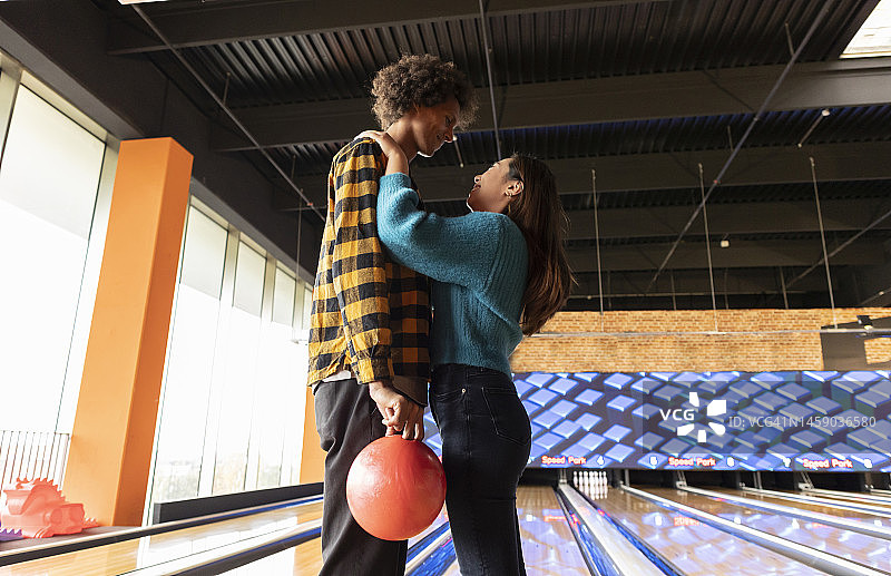 年轻夫妇在保龄球馆一起拿着保龄球图片素材