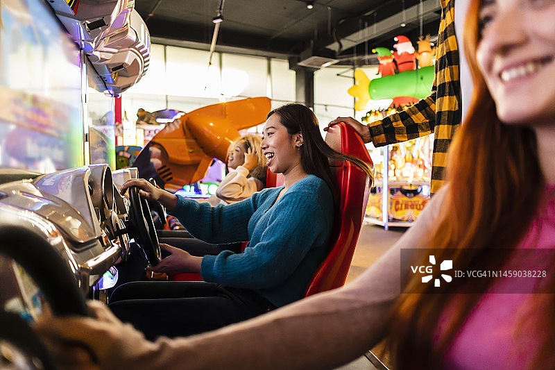 年轻女性在街机上玩驾驶模拟器图片素材