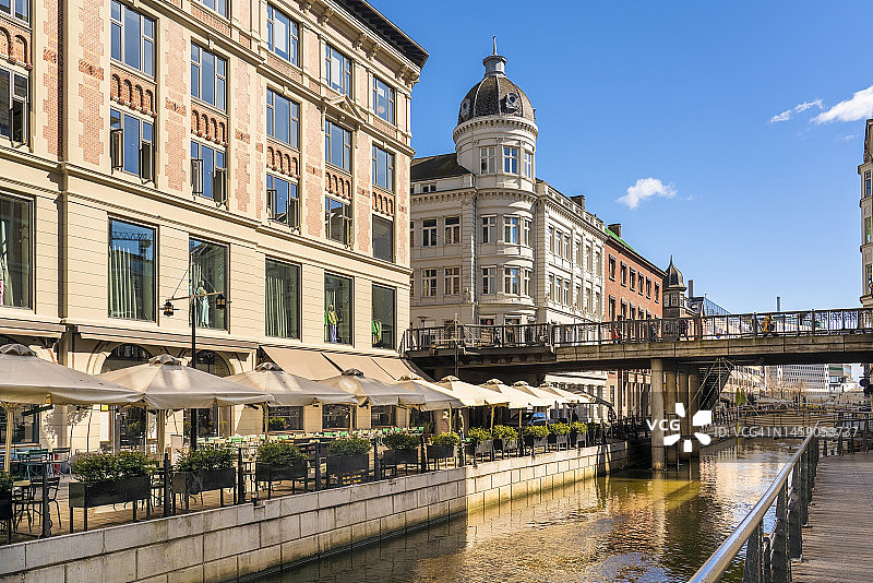 丹麦奥胡斯：阿布勒瓦登长廊旁的街边咖啡馆，背景是桥梁图片素材