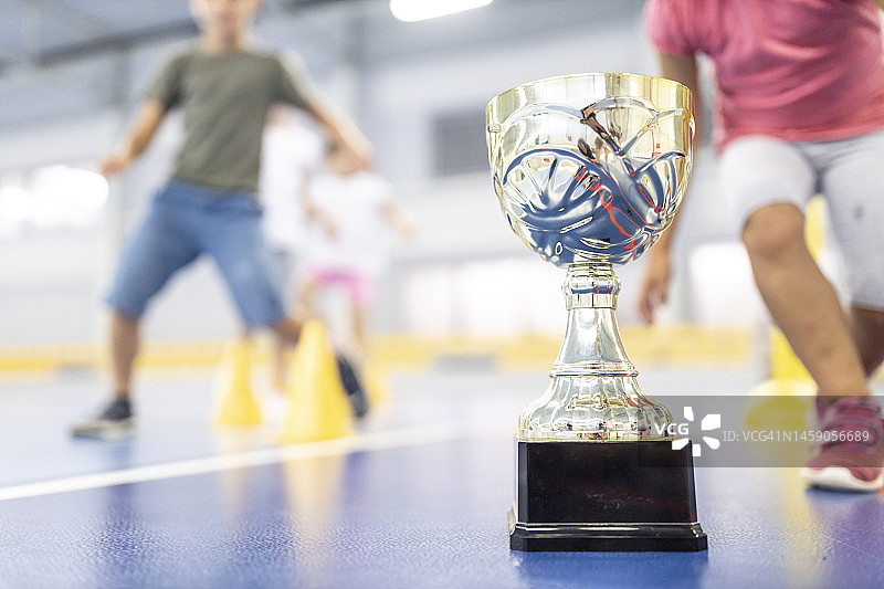 学校运动场上学生背景下的金属奖杯图片素材