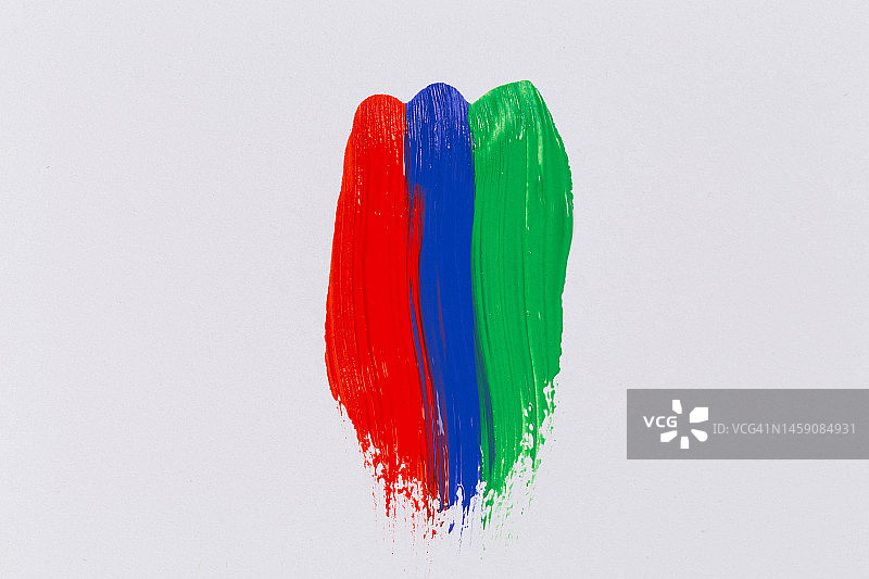 白色纸上的丙烯红蓝绿颜料，彩虹笔触图片素材