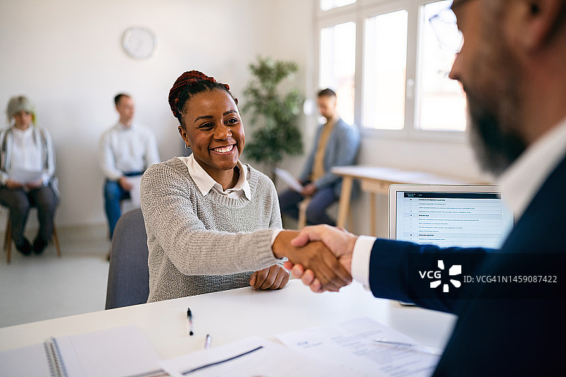 黑人女求职者在面试中与招聘人员握手图片素材