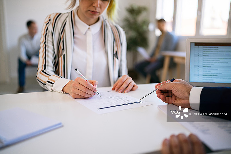 女应聘者在与招聘人员进行面试时填写申请表图片素材