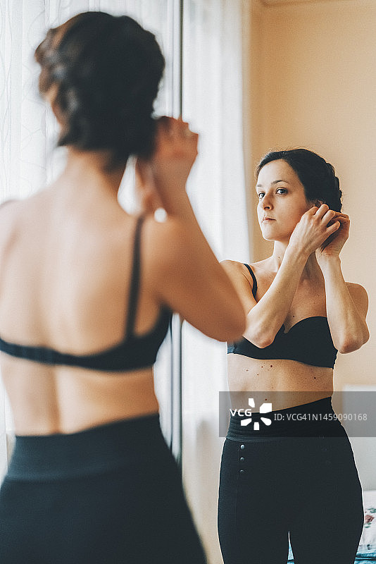 女人在镜子前戴耳环图片素材