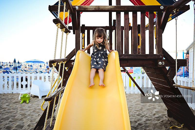 在户外黄色滑梯上的小女孩图片素材