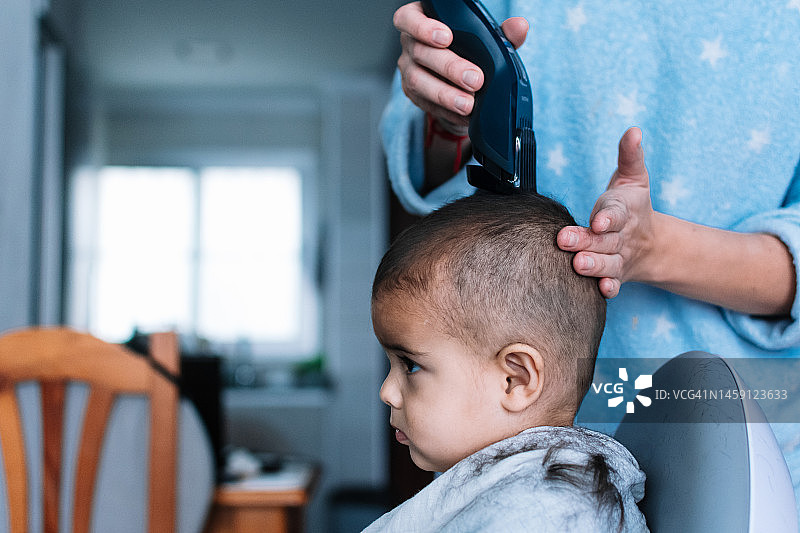 母亲给孩子剃头发图片素材