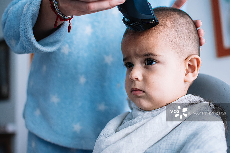 母亲给孩子剃头发图片素材
