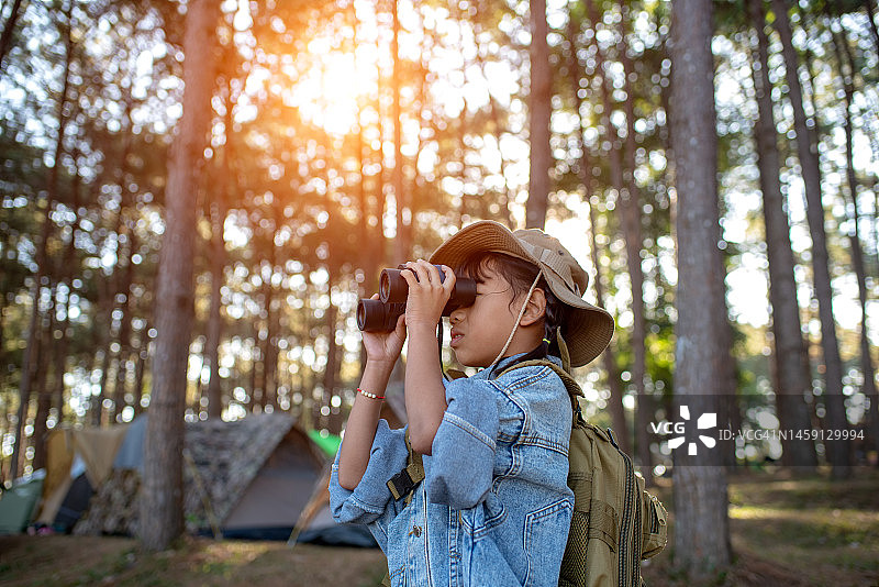 年轻女孩用双筒望远镜观察自然图片素材
