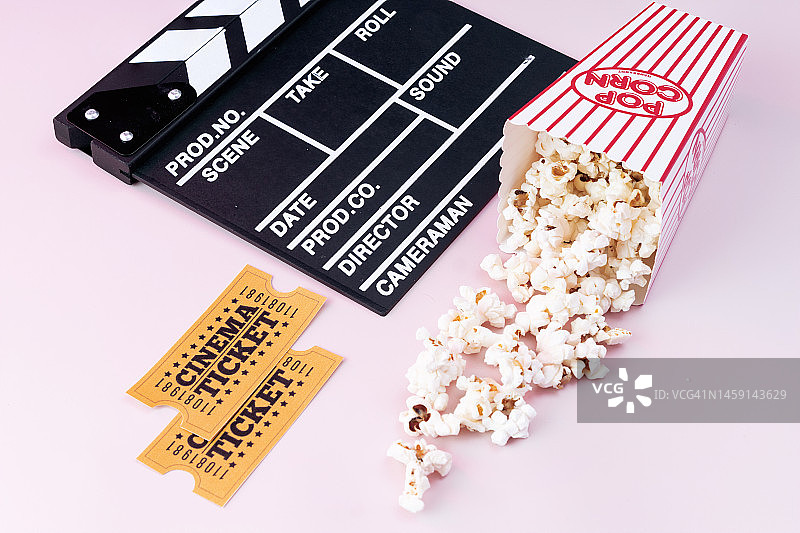 粉色背景上的电影场记板、电影票和爆米花图片素材